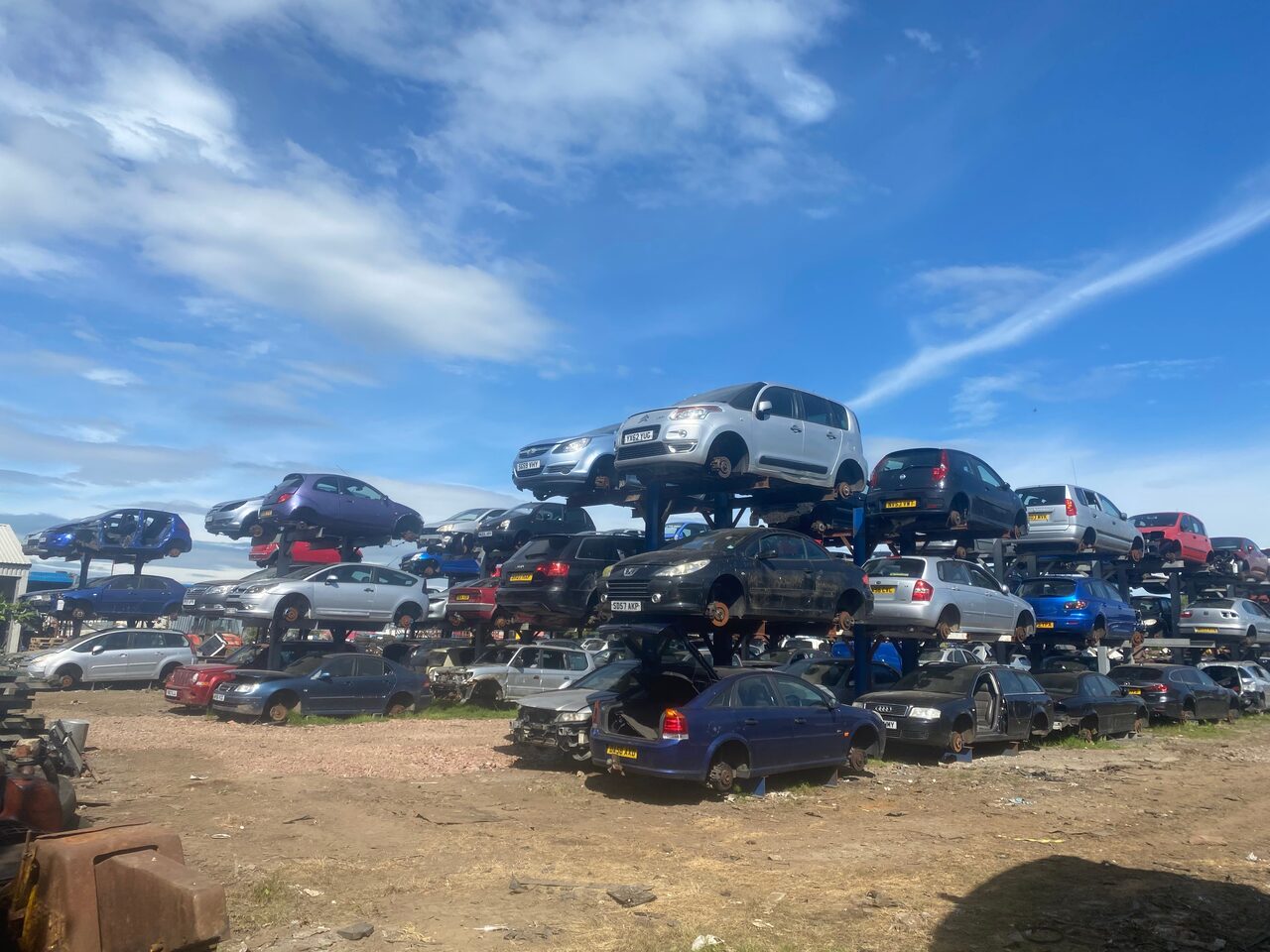 KC Forrest scrapyard crane and stacked vehicles
